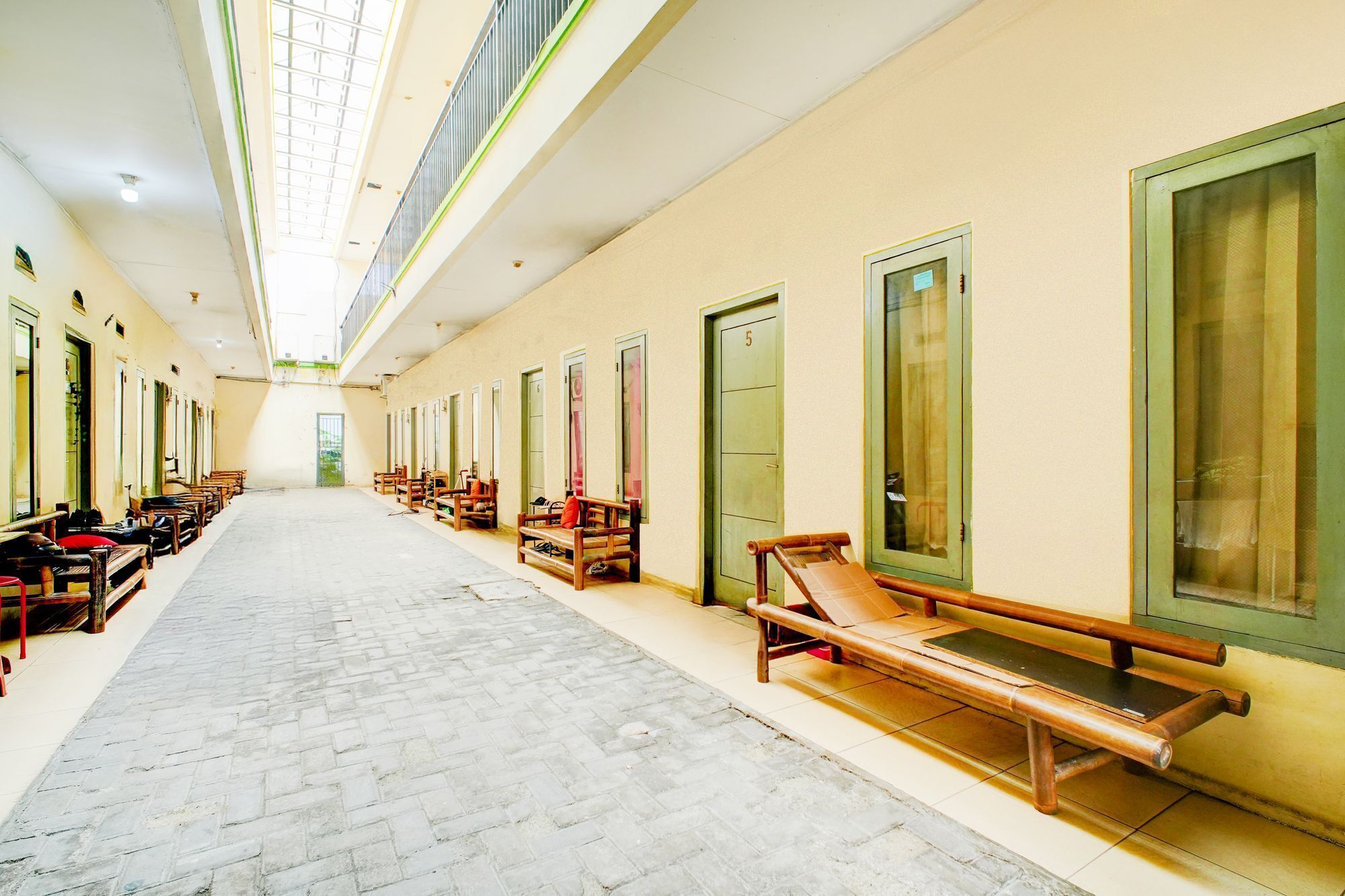 A long corridor with benches and doors, likely part of a hotel or similar accommodation.