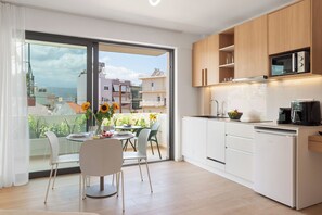 Superior appartement | Privékeuken | Een koelkast, een oven, een kookplaat, kookgerei, borden en bestek