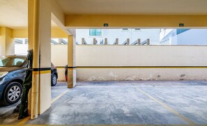 A parking garage with concrete floors and yellow lines marking parking spaces. - Apt W/barbecue 3 Minutes From Bombas Beach Fdl101 (Bombinhas)