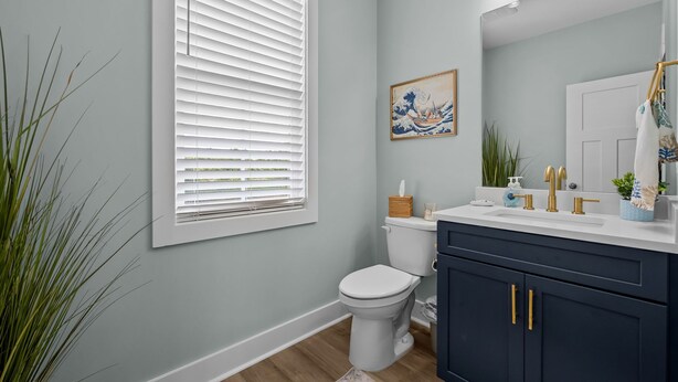 A bathroom with a toilet, sink, and cabinet. - Stunning Inlet Cove Townhome (Dock Holidays) (Beaufort)