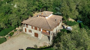 A stone building with a tiled roof, surrounded by dense greenery. - Villa Il Masseto, Gaiole in Chianti, Siena and Chianti (Gaiole in Chianti)