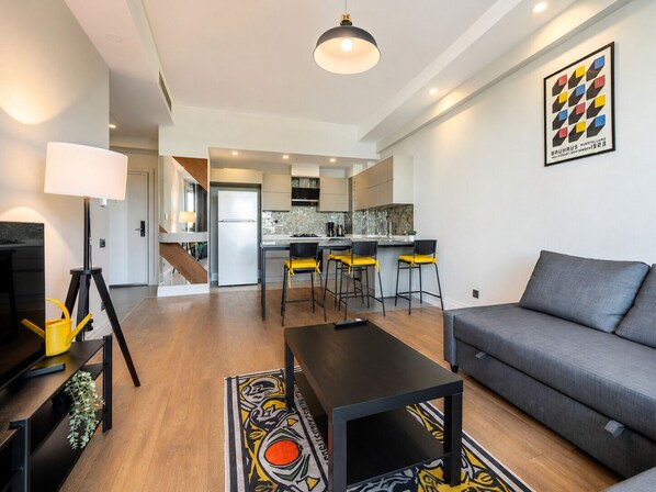 A modern apartment with a living area, kitchen, and dining space. - Maxihomes Sirella (Antalya)