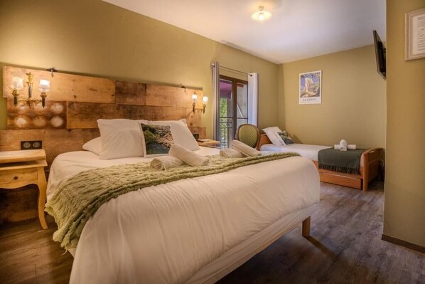 Une chambre à coucher avec un grand lit, une table de chevet, une chaise et une tête de lit en bois.