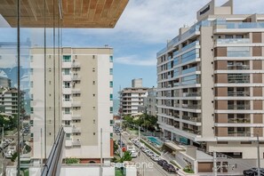 Um edifício moderno de vários andares com varandas e vista para a rua.