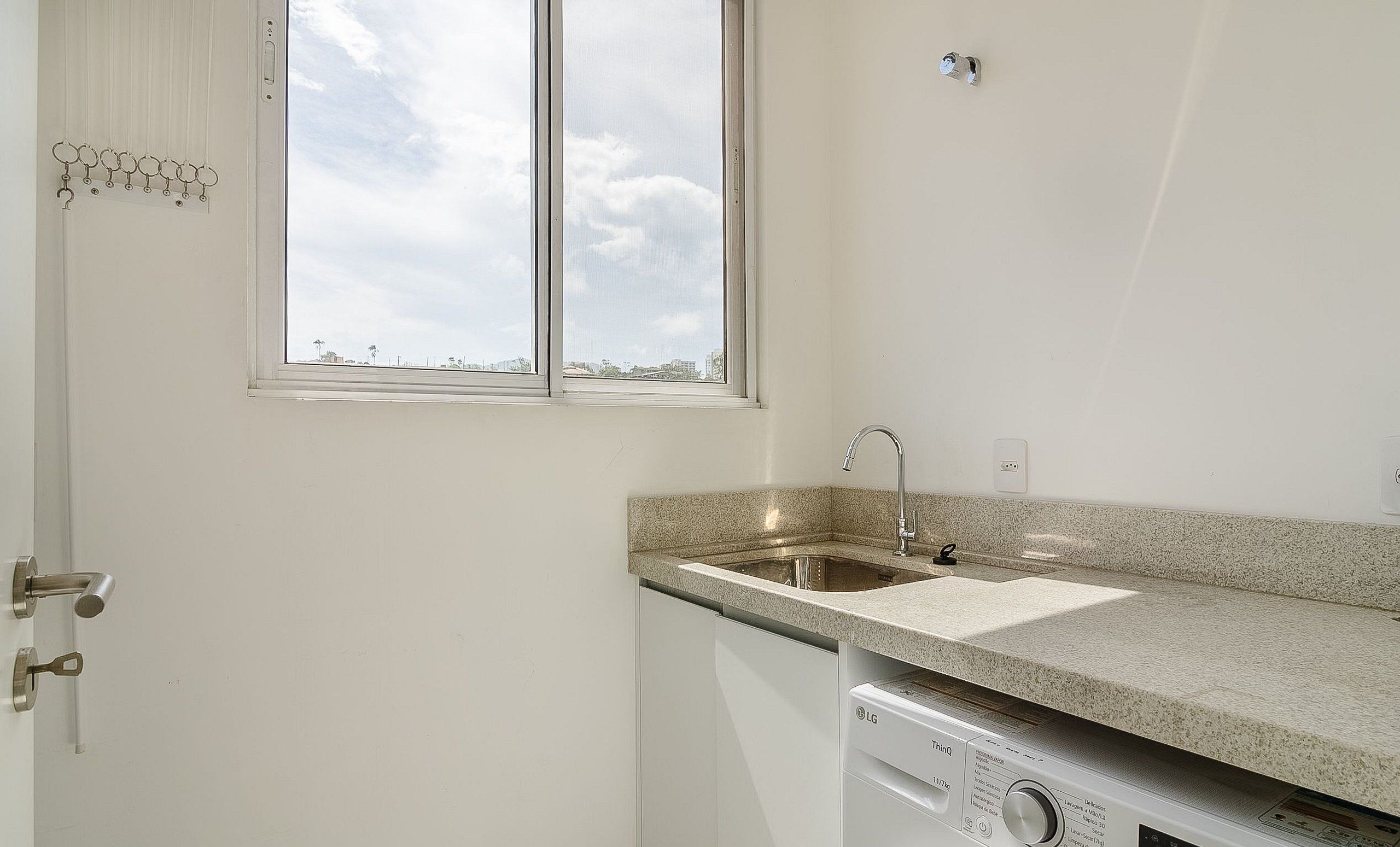 Una cocina con encimera de granito, lavavajillas integrado y ventana con vistas a la ciudad.