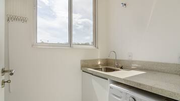 Una cocina con encimera de granito, lavavajillas integrado y ventana con vistas a la ciudad.