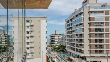 A modern multi-story building with balconies and a street view.