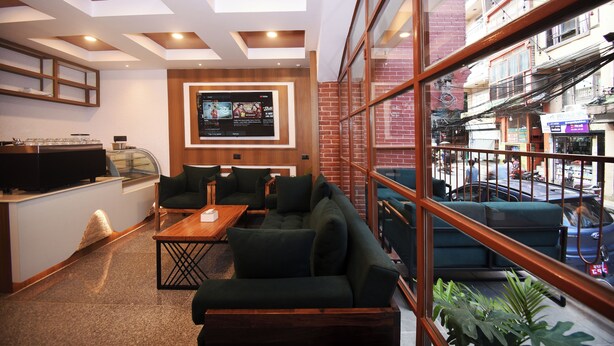A modern interior with a seating area, a counter, and a large window overlooking a street.