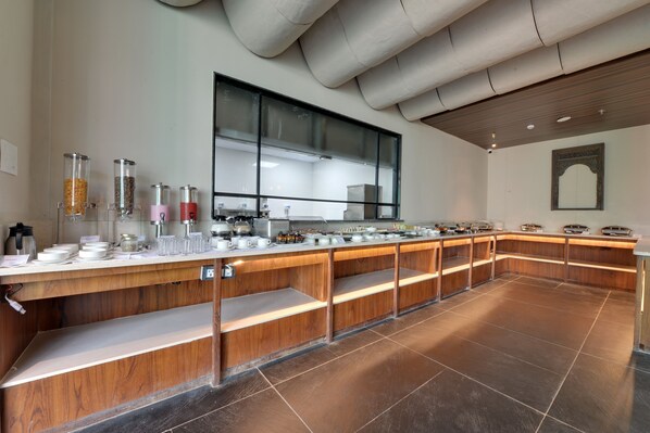 Un buffet composé de récipients en verre transparent, d’un grand miroir et d’un comptoir en bois.