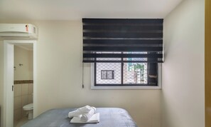 A hotel room with a bed, a window with blinds, a toilet, and a shower area. - Sea View Apt, Priv. Loc. 2min fr th sea BC Esa0902 (Balneário Camboriú)