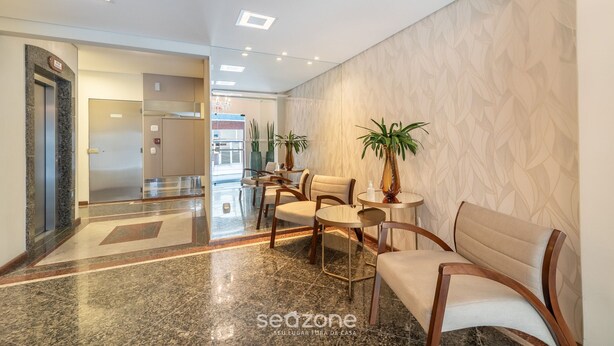A hotel lobby with a marble floor, a reception desk, seating area, and a patterned wall. - Sea View Apt, Priv. Loc. 2min fr th sea BC Esa0902 (Balneário Camboriú)