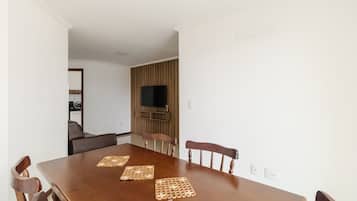 Un comedor con una mesa de madera, seis sillas y dos individuales tejidos.