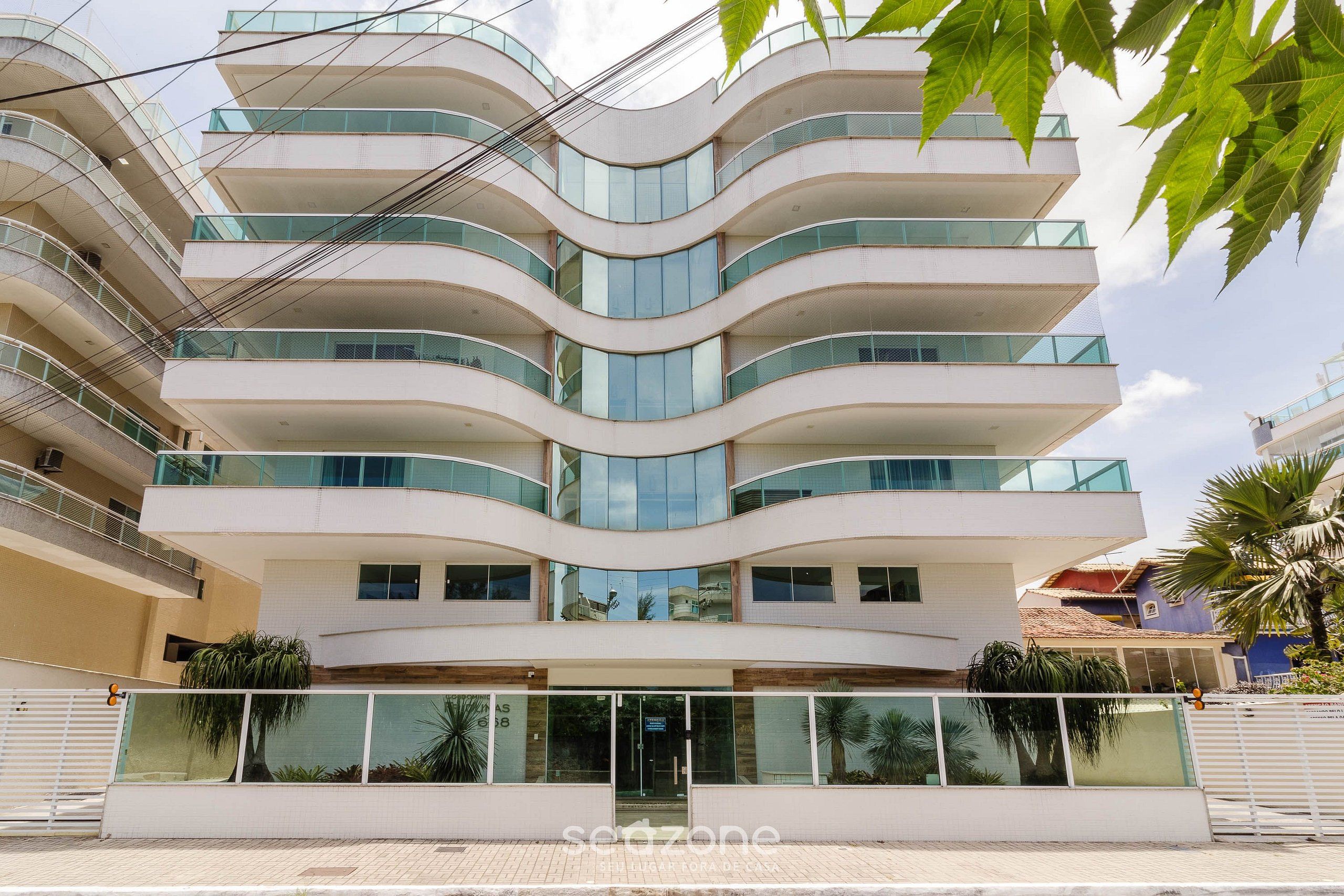 Un edificio de varios pisos con fachada curva, ventanas grandes y balcones.