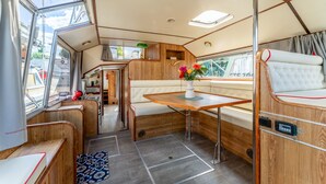 Ein kompaktes Wohnmobil-Interieur mit Küchenzeile, Sitzgruppe und kleinem Tisch.