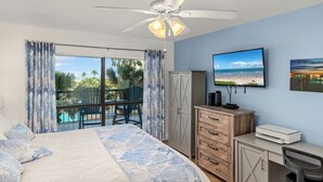 A bedroom with a bed, a desk, a television, and a view of the ocean. - Steps to Pool & Beach: South Padre Island Retreat! (South Padre Island)
