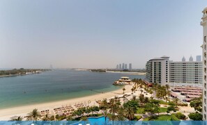 A beachfront hotel with a pool, beach, and city skyline. It features 1 bedroom, 1.5 bathrooms, and 2 guests accommodation. - Upgraded 1 Bed l Beach Access & Sea View l Palm (Palm Jumeirah)