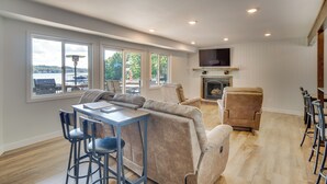 A modern living room with a sofa, chairs, a dining table, and a fireplace. - Fire Pit + Private Dock: Ozarks Family Escape! (Camdenton)