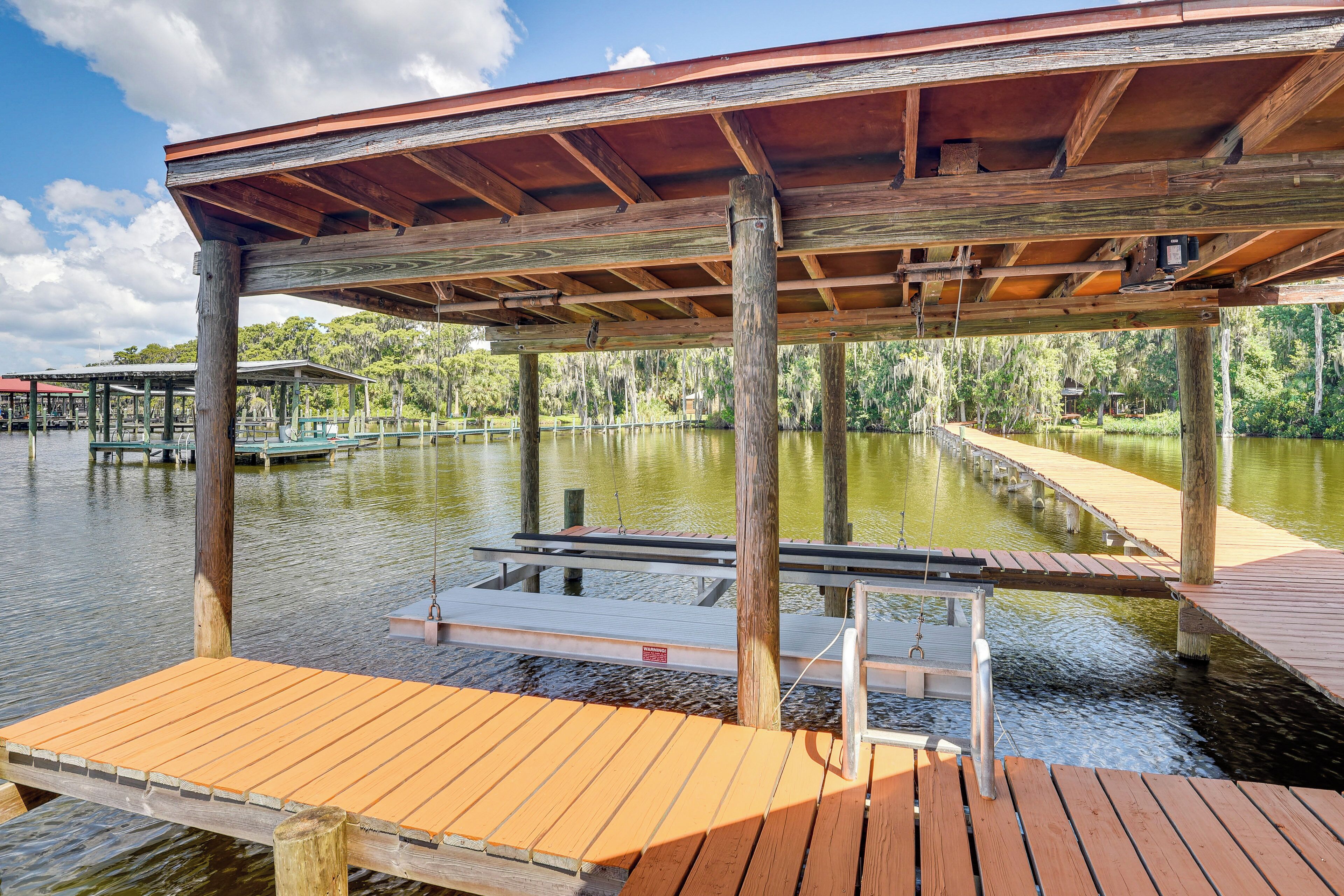 A wooden dock extending into a calm body of water, supported by sturdy wooden posts.