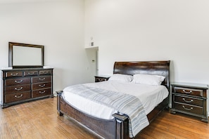 A bedroom with a wooden bed, a dresser, and a nightstand. - Spacious Getaway w/ Pool in La Mesa! (La Mesa)