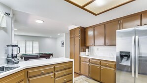 Una cocina con armarios de madera, un refrigerador de acero inoxidable y un lavavajillas empotrado.