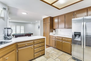 A kitchen with wooden cabinets, a stainless steel refrigerator, and a built-in dishwasher. - Spacious Getaway w/ Pool in La Mesa! (La Mesa)