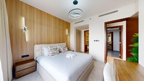 Una moderna camera d'albergo con un letto grande, pareti rivestite in legno, una scrivania e una pianta.