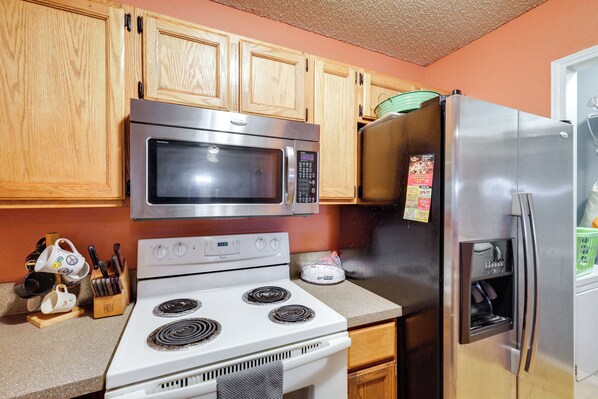 A kitchen with wooden cabinets, a stainless steel microwave, a refrigerator, and a stove. - 4 Blocks to At&t Stadium: 'entertainment Central!' (Arlington)