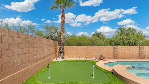 A backyard with a pool, artificial grass, and a palm tree. - Heated Pool & Spa: Catalina Mtn-view Home! (Oro Valley)