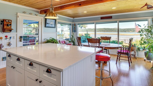 A spacious kitchen with a large island, wooden ceiling, and a view of the beach. - Across Water From Belfair SP: Hood Canal Cottage! (Belfair)