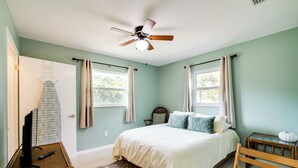A bedroom with a bed, a ceiling fan, a television on a stand, and a window with curtains. - Tree-lined Retreat 4 Mi to Three Sisters Springs! (Crystal River)