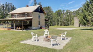 A rustic cabin with a stone fireplace and outdoor seating area. - 5 Mi to State Parks: Penfield Cabin w/ Fire Pit! (Penfield)