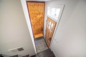 A narrow hallway with a wooden door and a window above it. - Fells Point Charm with a View (Baltimore)