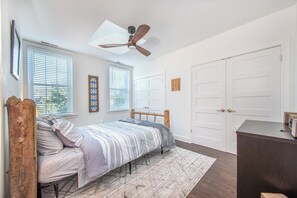 A bedroom with a bed, a ceiling fan, a window, and a wardrobe. - Fells Point Charm with a View (Baltimore)
