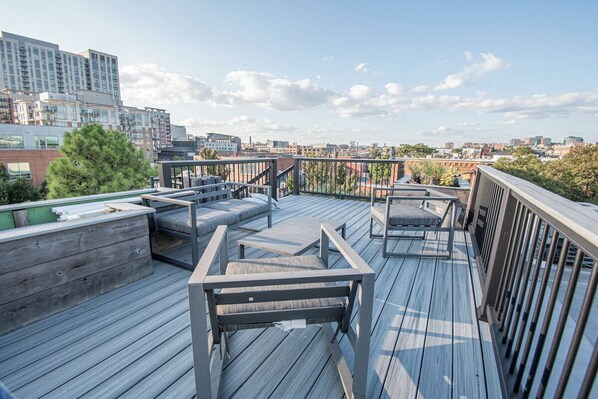 Eine Dachterrasse mit Sitzgelegenheiten und Blick auf die Stadt.