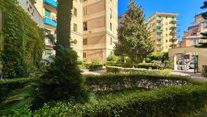 A residential area with multi-story buildings, a gated entrance, and well-maintained greenery. - Giano's Room Napoli (Naples)