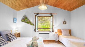 A bedroom with two beds, a window with a view, a wooden ceiling, and a hanging light fixture. - Maison La Plaine – Comfortable Holiday Home with Terrace in the Heart of Périgord (Saint-Laurent la Vallée)
