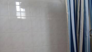 Un baño con bañera, inodoro y cortina de ducha.