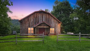 A rustic barn with a wooden exterior, a red door, and a fenced entrance. - Secluded Mountain Retreat With Stunning Views 4 Bedroom Home (Butler)