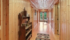 A wooden hallway with a bench, shelves with boxes, and a patterned rug. - Secluded Mountain Retreat With Stunning Views 4 Bedroom Home (Butler)