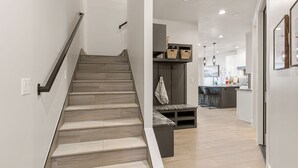 Una cocina moderna con una isla central, armarios empotrados e iluminación colgante.