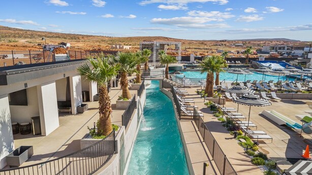A resort with a water slide, pool area, lounge chairs, and palm trees. - Sundance Den 3 Bedroom Home (Hurricane)