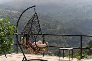Un fauteuil suspendu offrant une vue sur un paysage montagneux.