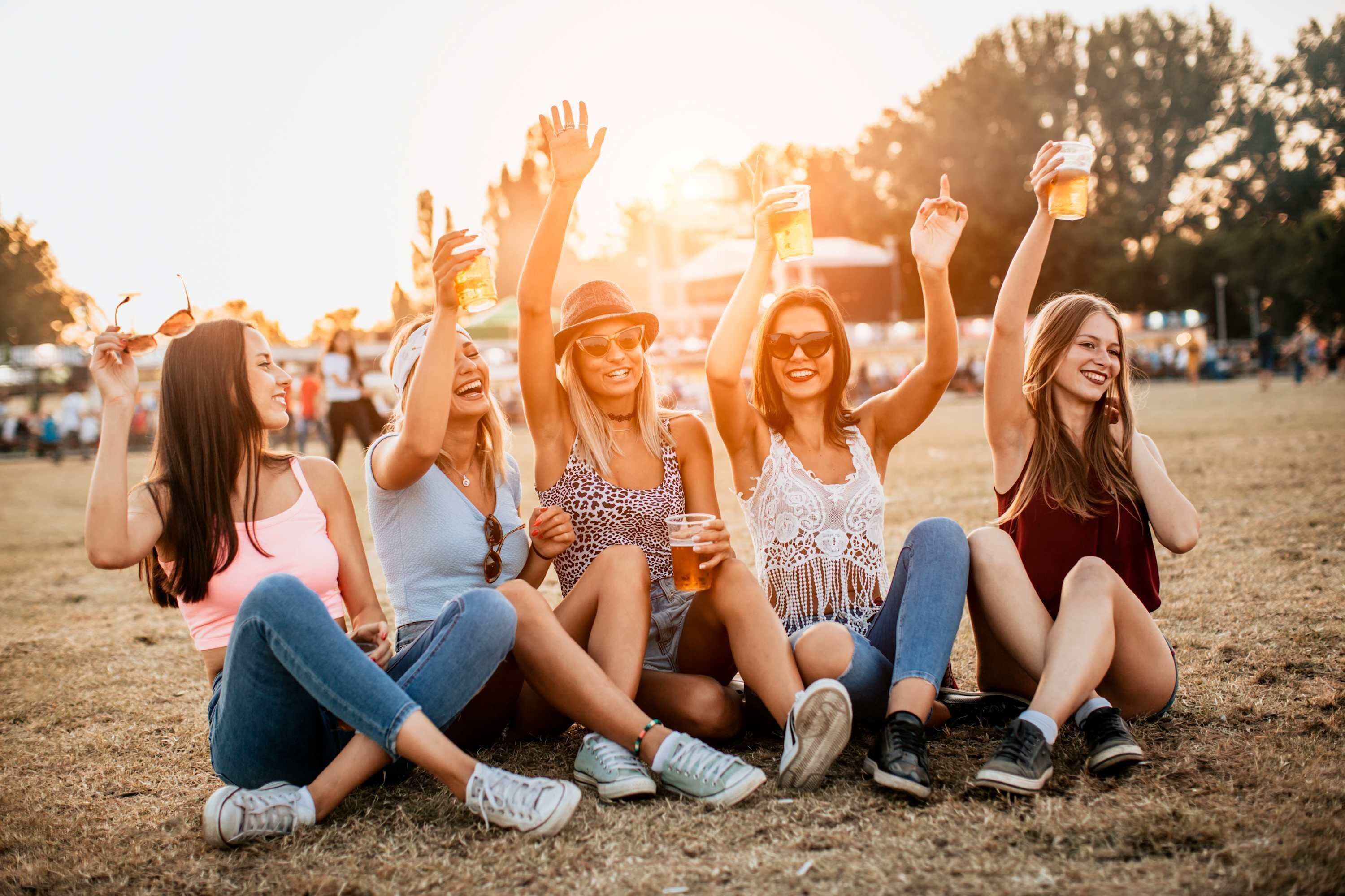 A group of people sitting on grass at an outdoor event.