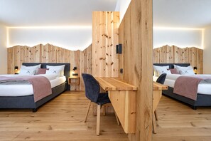 A modern hotel room with two beds, a wooden desk, and a chair. - Spacious Alpine-style apartment with private garden and pool view. (Fiumes)