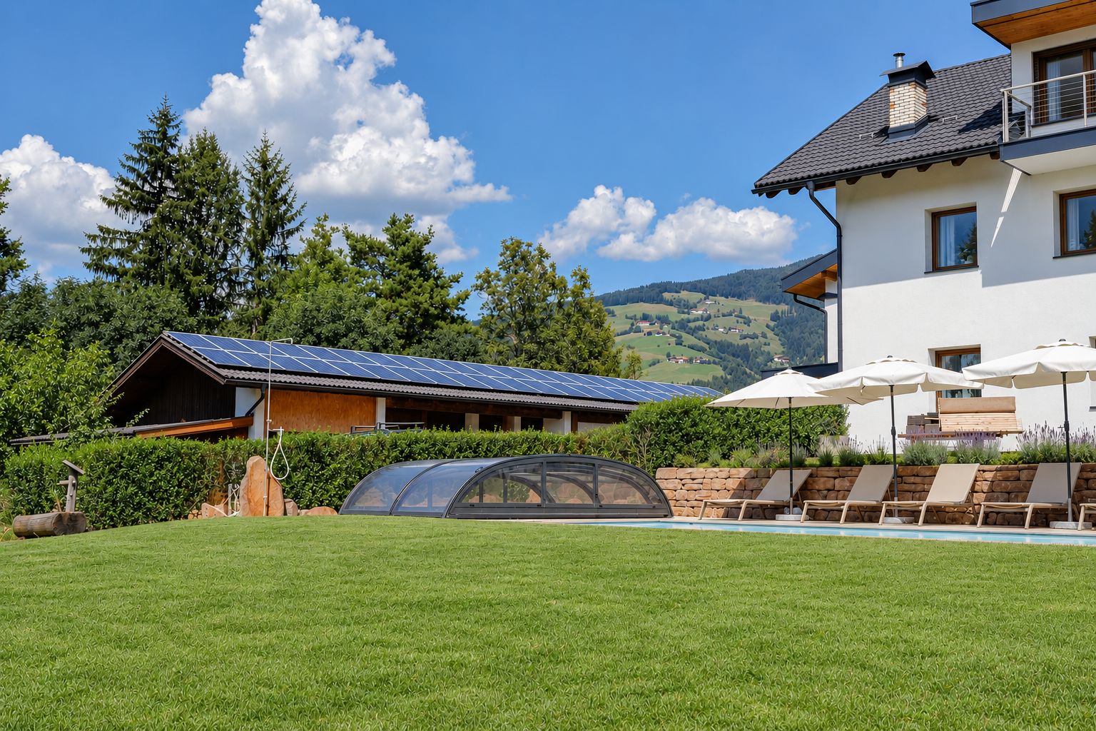 Een woonhuis met een zwembad, een overdekte autocarport en een woning met zonnepanelen.
