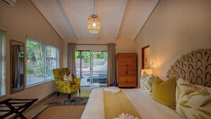 Ein Hotelzimmer mit Bett, Stuhl, Kleiderschrank und Blick ins Freie.