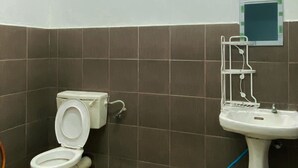 Ein Badezimmer mit Toilette, Waschbecken und Fenster.