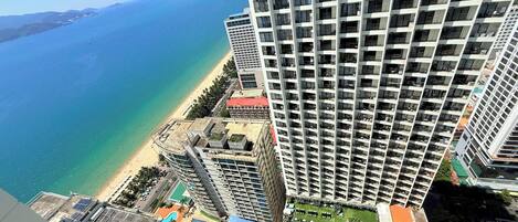 Un edificio de gran altura con piscina en la azotea y vistas a la playa.