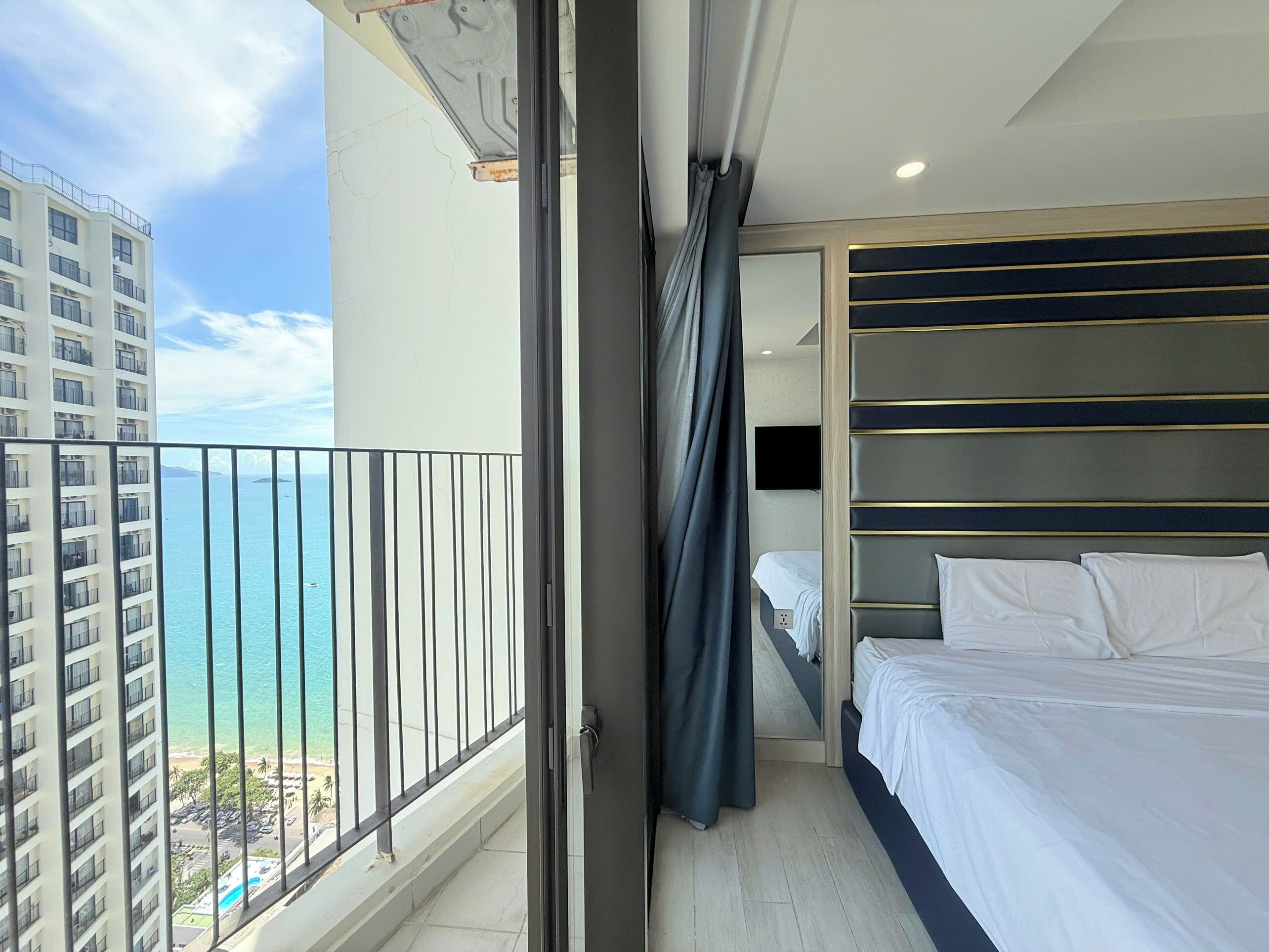 Une chambre d’hôtel avec un balcon, un lit et une télévision.