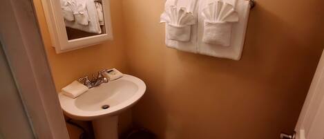 A bathroom with a sink, mirror, and towel rack.